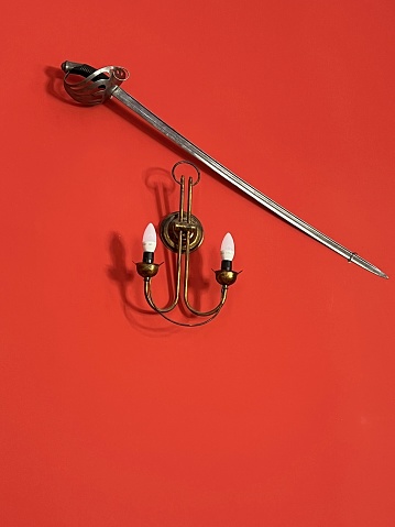 Sword and lamp on a red wall