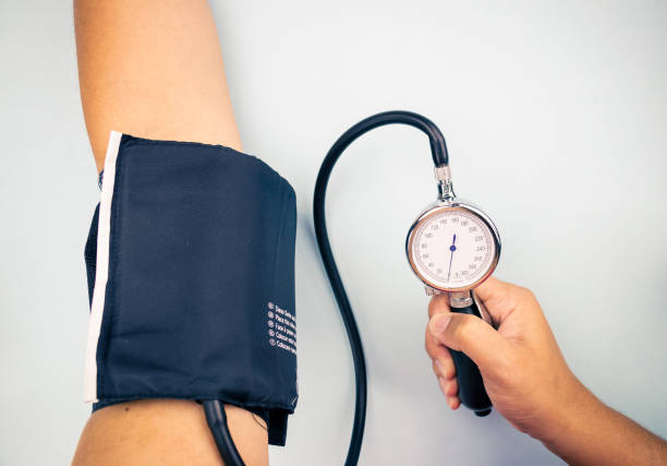 sanitary measuring the tension to person with sphygmomanometer stock photo