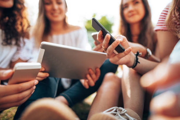 istock friends using social media together at the park 1414757787