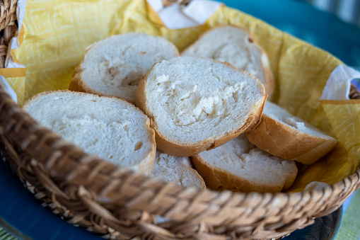 sliced white bread in a wooden basket in selective focus