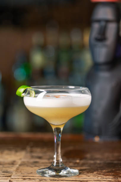 Vanilla Sour cocktail with egg white and lemon juice  on the bar. Blurred background. stock photo