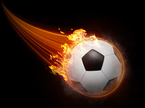 The soccer ball flies with lightning fast magical effects in a futuristic orange flame displaying a black background.