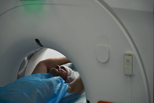 istock Man lies in tomography camera on diagnostic procedure upper body 1414762387