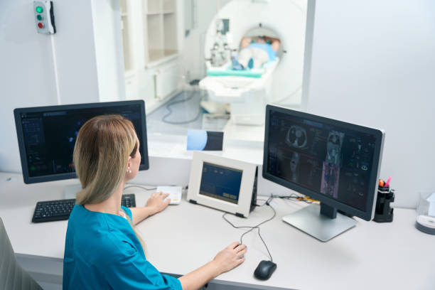 istock Woman diagnostician sits at the table and makes tomography 1414762432