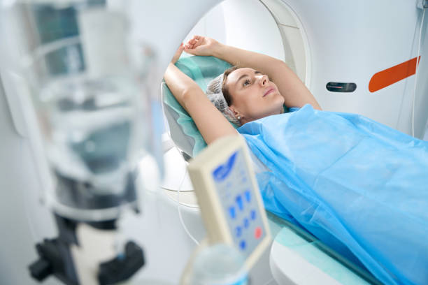 istock Woman with her arms outstretched is placed in tomography camera 1414762456