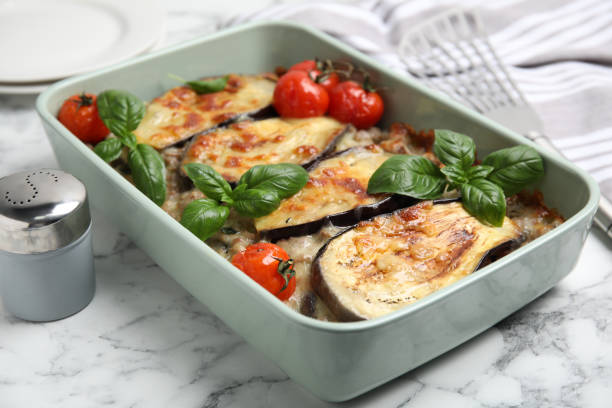 istock Delicious eggplant lasagna in baking dish on white marble table 1414762809