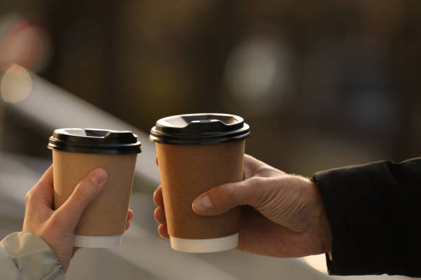 istock Couple with takeaway coffee cups outdoors, closeup 1414762865