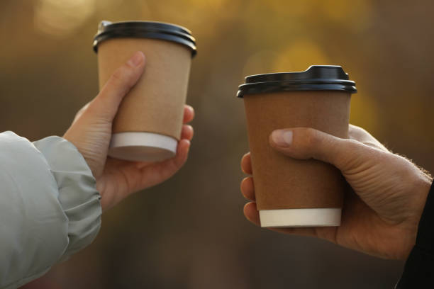 istock Couple with takeaway coffee cups outdoors, closeup 1414762939