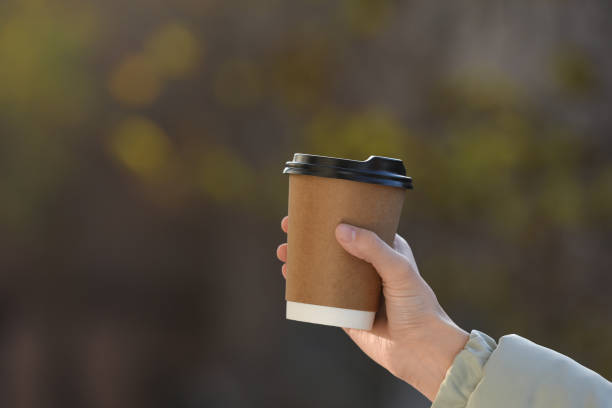 istock Woman with takeaway coffee cup outdoors, closeup 1414762948