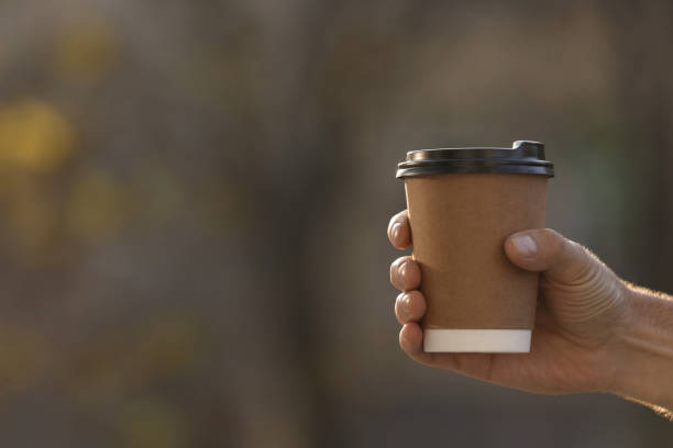 istock Man with takeaway coffee cup outdoors, closeup. Space for text 1414762956