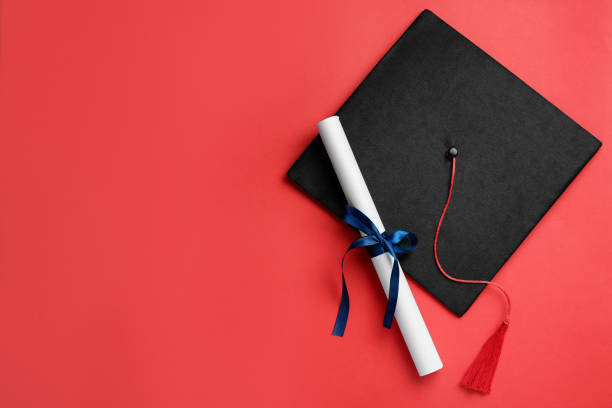 istock Graduation hat and diploma on red background, flat lay. Space for text 1414762960