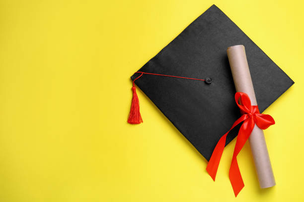 istock Graduation hat and diploma on yellow background, flat lay. Space for text 1414763557