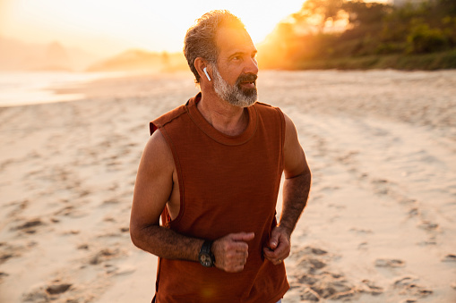 Portrait of an active senior man at the beach at sunset