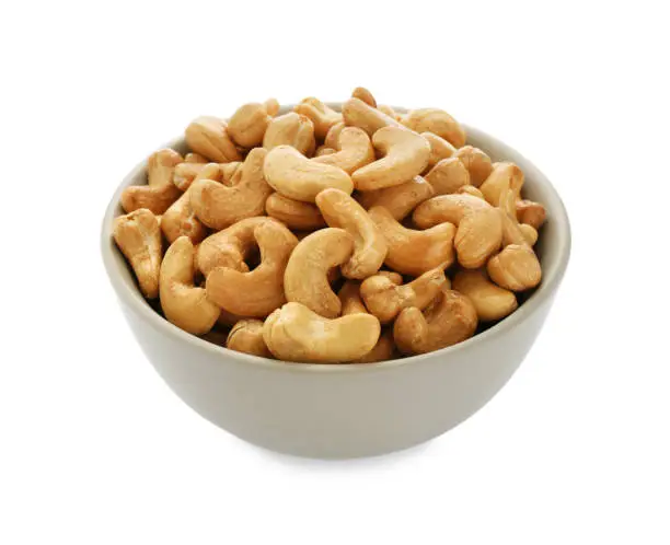 Bowl of tasty organic cashew nuts isolated on white
