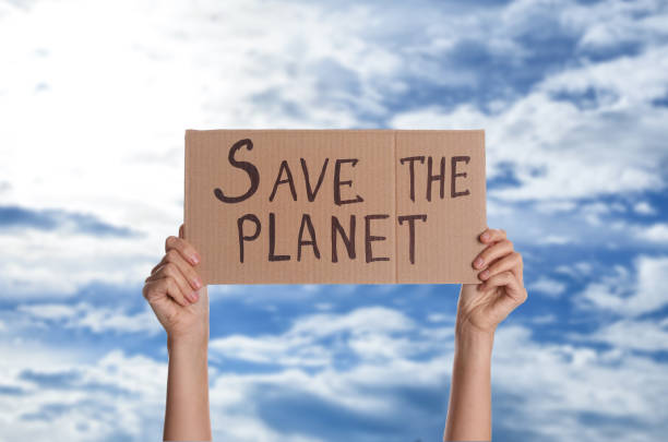 istock Protestor holding placard with text Save The Planet against blue sky, closeup. Climate strike 1414764886