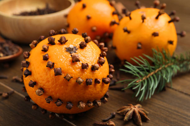 Pomander balls made of tangerines with cloves and fir branch on wooden table, closeup. Space for text Pomander balls made of tangerines with cloves and fir branch on wooden table, closeup. Space for text scent container stock pictures, royalty-free photos & images