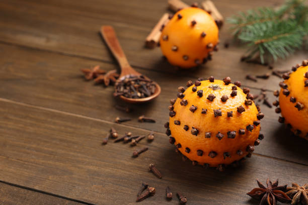 Pomander balls made of tangerines with cloves on wooden table. Space for text Pomander balls made of tangerines with cloves on wooden table. Space for text scent container stock pictures, royalty-free photos & images