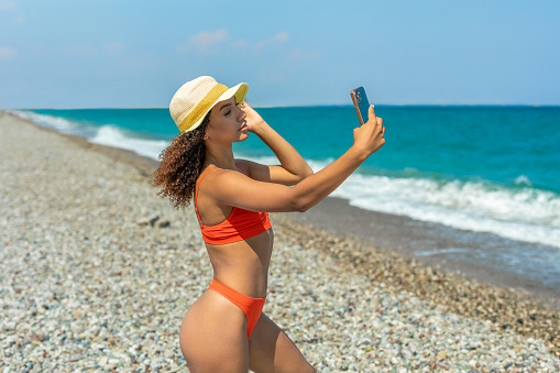 Woman taking selfie on the beach