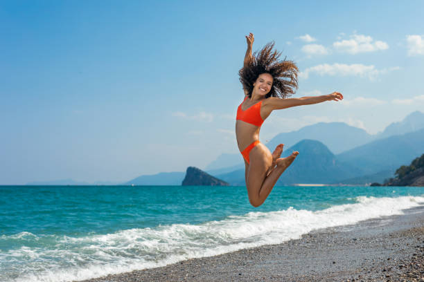 istock Woman jumping on the beach 1414765252