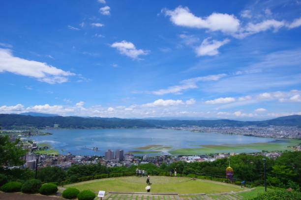 Scenery of Japan/Lake Suwa Nagano, Japan -August 13, 2019: Lake Suwa is a lake in the Suwa Basin of Nagano Prefecture, spanning three cities: Okaya City, Shimosuwa Town, and Suwa City. The area is 12.81㎢. The largest lake in Nagano Prefecture.
In recent years, general freezing has decreased. The surface of the lake freezes over in winter, and the thickness of the ice reaches a certain level.
As the temperature rises during the day, the ice melts, and at night the temperature drops and the ice grows.After that, it expands and the area of the lake surface becomes insufficient.Cracks in the ice run up on the surface of the lake with a loud sound.This phenomenon is called 'omiwatari'.In the winter of the year when 'Omiwatari' appears, a Shinto ritual is held at Yatsurugi Shrine.
The record of 'Omiwatari' is from 1443.It continues to be recorded every year to this day.Some years are missing.However, as of 2022, it is an almost continuous weather record for about 577 years. It is a valuable resource in the world. suwa lake photos stock pictures, royalty-free photos & images