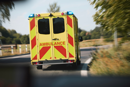 Ambulance car of emergency medical service on road in blurred motion. Themes rescue, urgency and health care.
