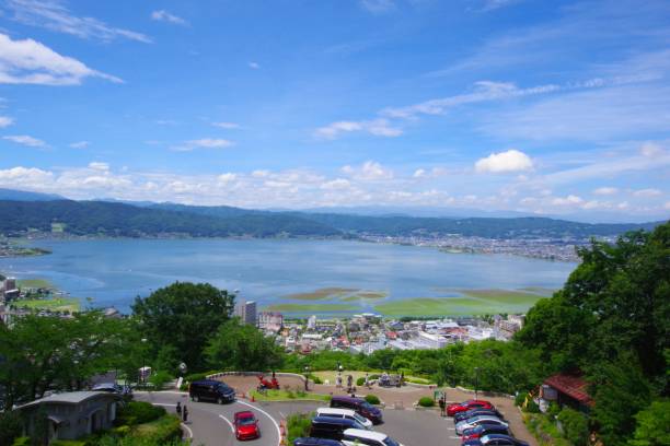 Scenery of Japan/Lake Suwa Nagano, Japan -August 13, 2019: Lake Suwa is a lake in the Suwa Basin of Nagano Prefecture, spanning three cities: Okaya City, Shimosuwa Town, and Suwa City. The area is 12.81㎢. The largest lake in Nagano Prefecture.
In recent years, general freezing has decreased. The surface of the lake freezes over in winter, and the thickness of the ice reaches a certain level.
As the temperature rises during the day, the ice melts, and at night the temperature drops and the ice grows.After that, it expands and the area of the lake surface becomes insufficient.Cracks in the ice run up on the surface of the lake with a loud sound.This phenomenon is called 'omiwatari'.In the winter of the year when 'Omiwatari' appears, a Shinto ritual is held at Yatsurugi Shrine.
The record of 'Omiwatari' is from 1443.It continues to be recorded every year to this day.Some years are missing.However, as of 2022, it is an almost continuous weather record for about 577 years. It is a valuable resource in the world. suwa lake photos stock pictures, royalty-free photos & images