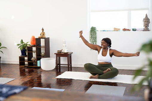 Happy smiling yoga instructor greets other yogi at class