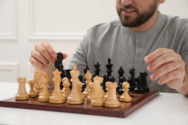 istock Man playing chess at white table indoors, closeup 1414766328
