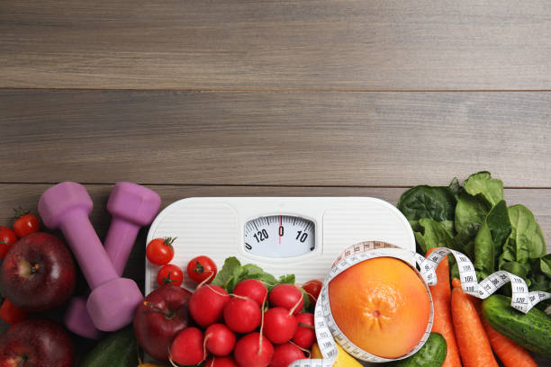 istock Flat lay composition with scales and healthy food on wooden table, space for text 1414766485