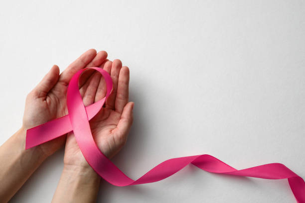 Woman holding pink ribbon on white background, top view with space for text. Breast cancer awareness concept stock photo