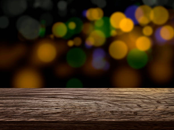 istock Wooden table top on shining bokeh background. concept for chossing best design 1414769830
