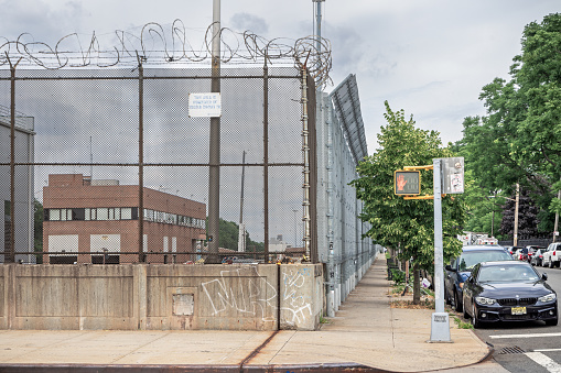 Brooklyn, New York, NY, USA - July 6th 2022: High and strong fence with barbed wire on top in a industrial part of Brooklyn