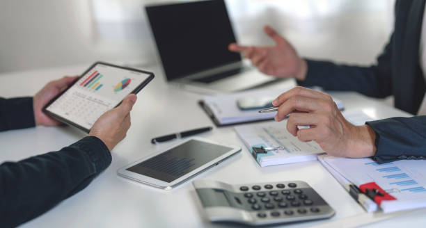 istock Business professionals. Cropped shot of business people analyzing data using computer while spending time in the office. 1414771034
