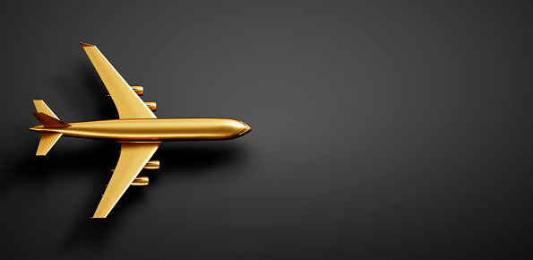 Golden airplane on dark background with copy space