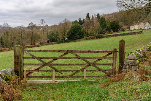 An old rustic wooden farm gate on a winter cloudy day.