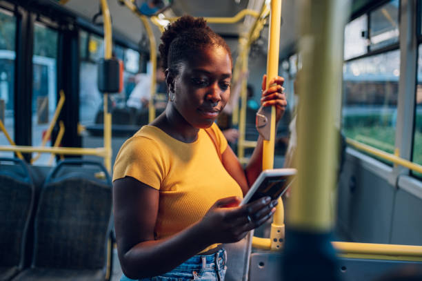 istock African american woman using smartphone while riding a bus in the night 1414774306