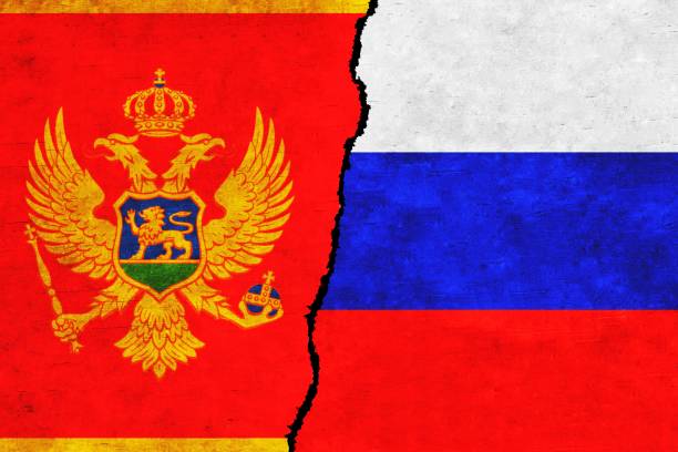 istock Russia and Montenegro painted flags on a wall with a crack. 1414775591
