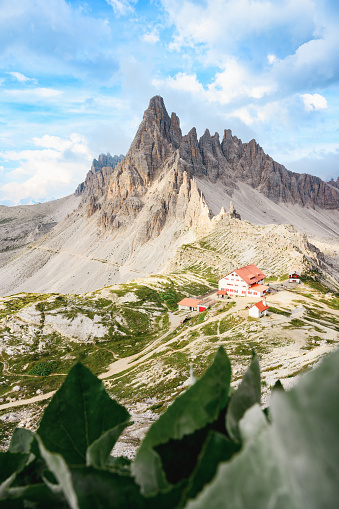 Stunning view of a mountain hut during a beautiful sunny day with Mt Paterno in the background. The Three Peaks of Lavaredo are the undisputed symbol of the Dolomites, Italy