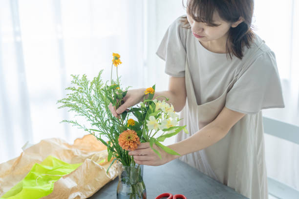 Japanese woman arranging flowers at home stock photo