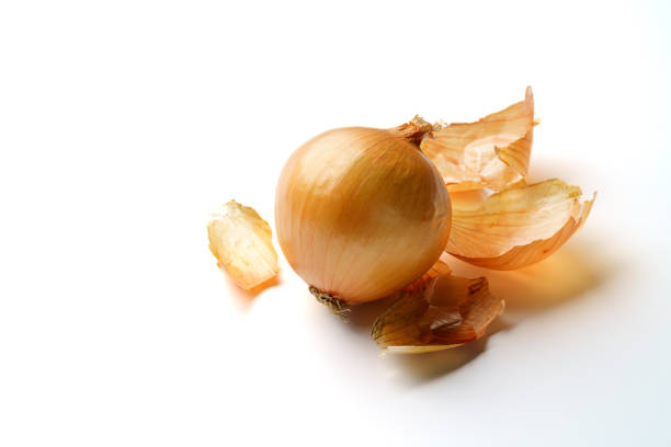 Raw unpeeled onions on white background