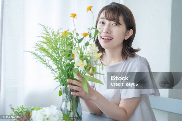 自宅で花を並べる日本人女性