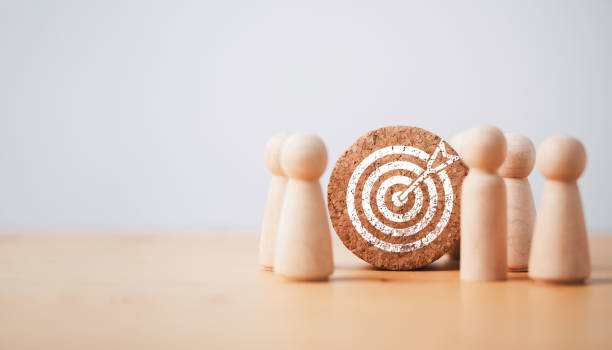 istock Wooden miniature figures standing with dartboard and arrow for setup business objective target and goal concept. 1414777896