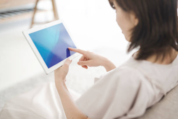istock Japanese woman operating a tablet devic 1414778147