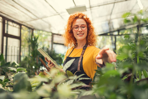 istock Young redhead woman working in a flower shop using digital tablet 1414778209
