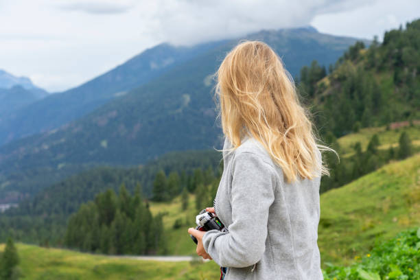 istock Blonde photographer observes the valley. 1414780771