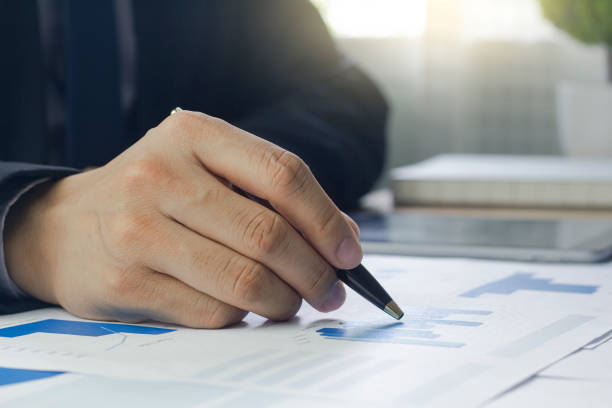 istock Close up of a Business man hand analyzing chart and graph showing changes on the market. 1414781783
