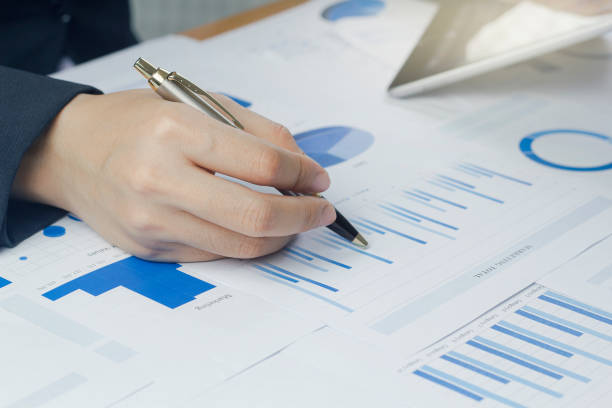 istock Close-up hand holding pen business woman  analyzing chart and graph showing changes on the market. 1414783265