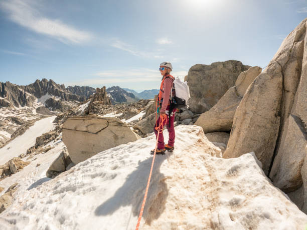 l’alpiniste de femme mène la voie à l’étape finale sur un sommet de roche - european alps mountain mountain peak rock photos et images de collection