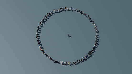 High angle view of large group of smiling people standing embraced in a circle and looking at the camera. Isolated on white.