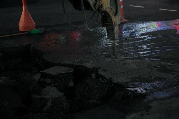 istock A heavy equipment is breaking the asphalt 1414785473